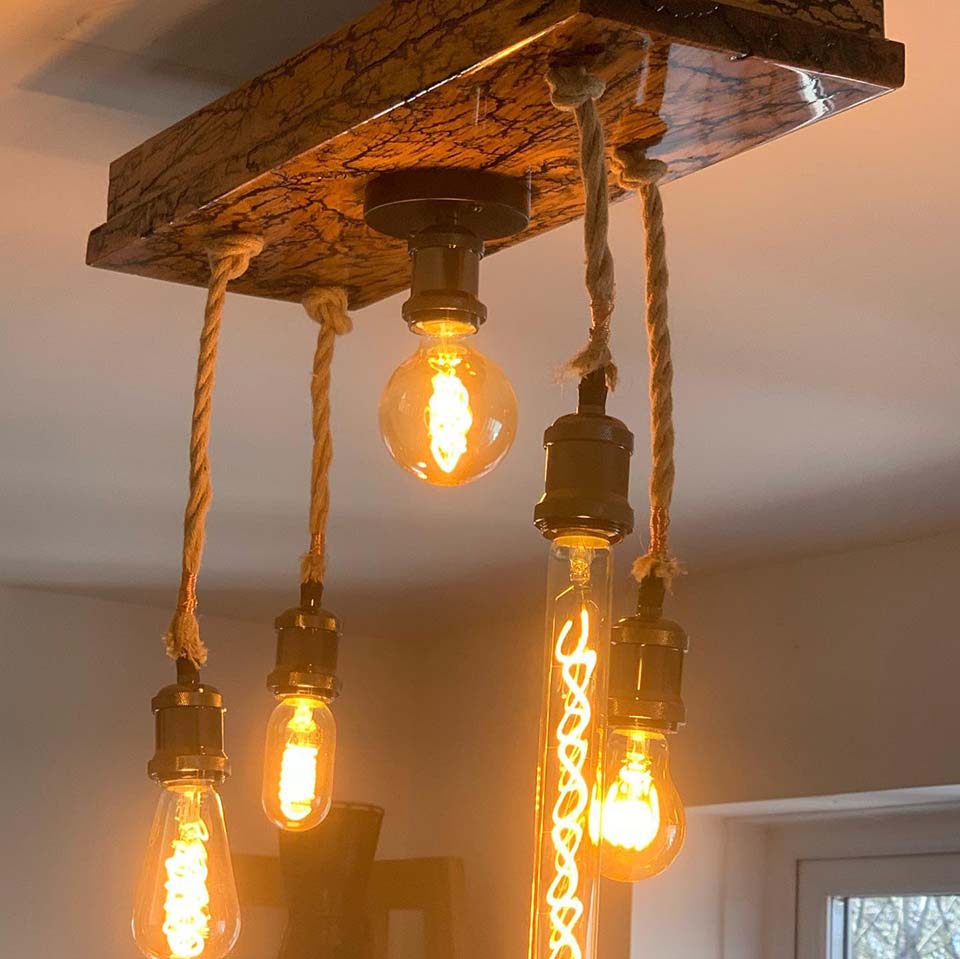 Wooden light fixture with bulbs hanging by rope